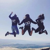 Trois jeunes personnes de dos sautant dans les airs au soleil.